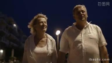 老夫妇在有风的夜晚在度假村散步和在手<strong>机上</strong>自拍的斯坦尼康镜头